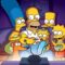 A imagem mostra a família Simpson reunida no sofá da sala, assistindo televisão. Homer está ao centro, comendo pipoca, enquanto segura Maggie no colo. Marge, com seus característicos cabelos azuis altos, está sentada ao lado esquerdo dele, abraçando-o. À direita, Lisa aparece animada segurando uma tigela de cereal ou pipoca, e Bart observa curioso por trás de Homer. O cachorro da família, Ajudante de Papai Noel, também está presente, olhando para a tela. Todos estão iluminados pela luz azulada da TV em frente a eles.