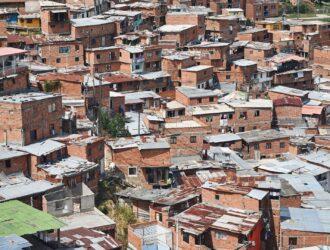 A imagem enviada mostra claramente o Complexo do Alemão, com suas construções irregulares e o sistema de teleférico que cruza a comunidade — um dos marcos visuais da região. O contraste entre a favela e a área urbana mais desenvolvida ao fundo reforça o cenário de desigualdade que marca o território