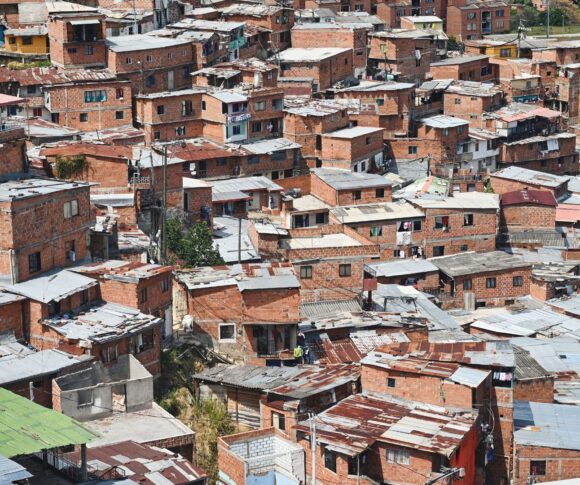 A imagem enviada mostra claramente o Complexo do Alemão, com suas construções irregulares e o sistema de teleférico que cruza a comunidade — um dos marcos visuais da região. O contraste entre a favela e a área urbana mais desenvolvida ao fundo reforça o cenário de desigualdade que marca o território