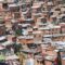 A imagem enviada mostra claramente o Complexo do Alemão, com suas construções irregulares e o sistema de teleférico que cruza a comunidade — um dos marcos visuais da região. O contraste entre a favela e a área urbana mais desenvolvida ao fundo reforça o cenário de desigualdade que marca o território