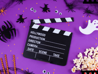 A imagem mostra um cenário com fundo roxo, com detalhes típicos do Halloween, como teias de areia no canto, morceguinhos pretos, olhos de medo e fantasma. No canto direito inferior está um balde de pipoca, e no centro há um símbolo de gravação de cenas em filmes