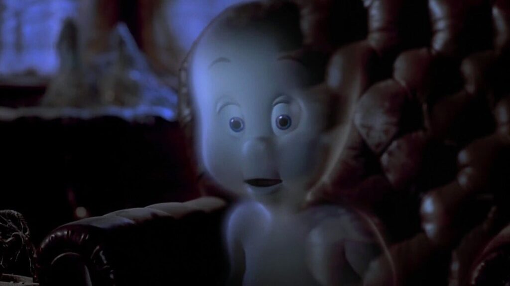 Cena do filme “Gasparzinho, o Fantasminha Camarada” mostra o simpático fantasma Gasparzinho sentado em uma poltrona escura, iluminado por uma luz azulada que destaca sua forma translúcida e expressão curiosa, transmitindo um clima leve e misterioso ao mesmo tempo.