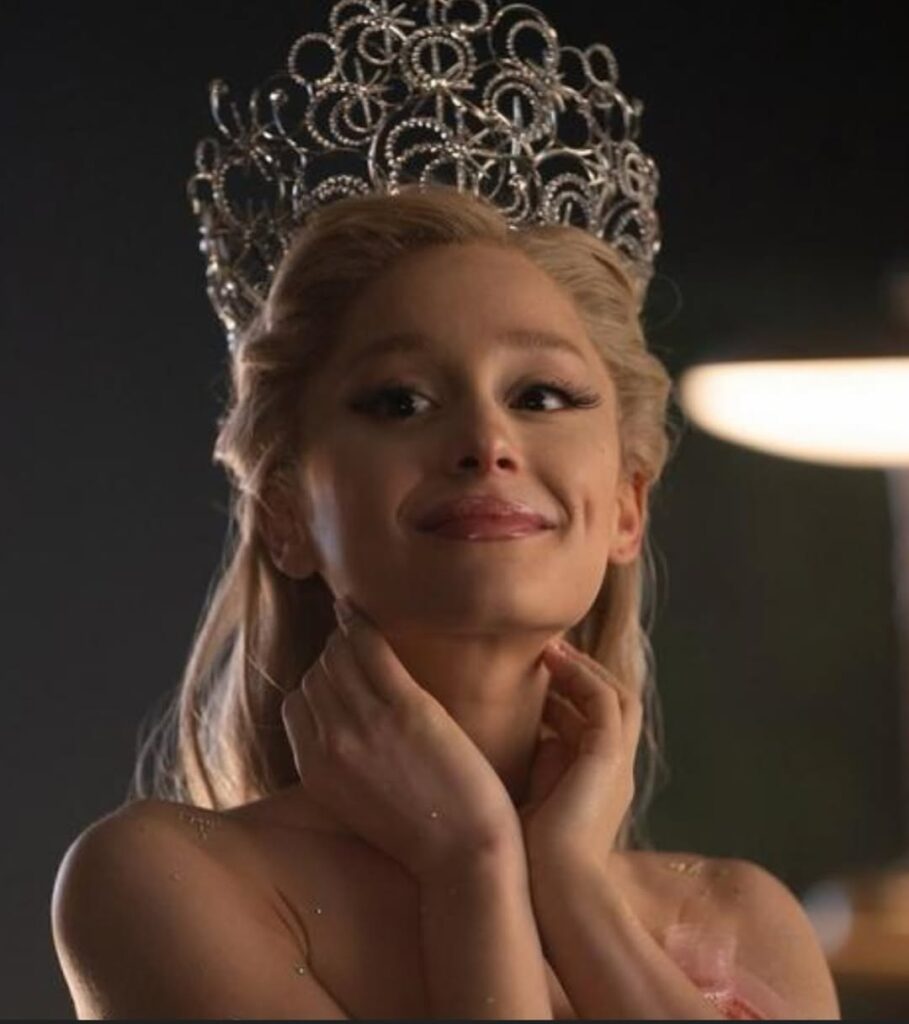 A artista está caracterizada como sua personagem Glinda do filme Wicked. Aparece tocando levemente as mãos em ambos os lados de seu pescoço enquanto sorri.Seus cabelos e sobrancelhas são loiros. No topo de sua cabeça possui uma coroa extravagante, com um padrão geométrico e ornamentada com inúmeros cristais cintilantes.