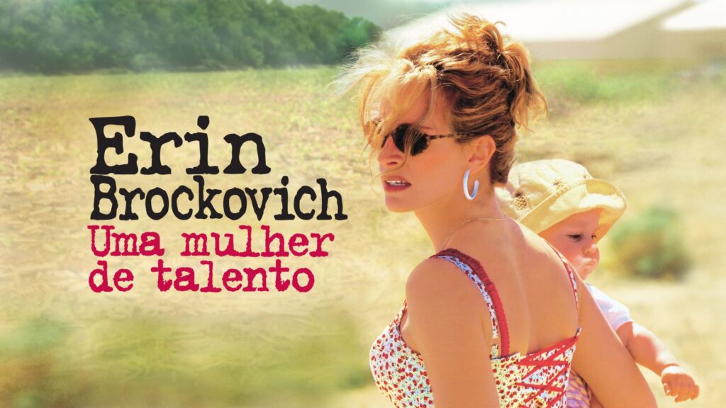 A imagem é um cartaz do filme Erin Brockovich: Uma Mulher de Talento. No lado direito, vemos uma mulher loira (interpretada por Julia Roberts) usando óculos escuros e brincos grandes de argola, vestindo um vestido com estampa floral e alças vermelhas. Ela carrega um bebê nas costas, que usa um chapéu claro. O fundo mostra um campo aberto com vegetação esmaecida, transmitindo sensação de calor e luz intensa. No lado esquerdo, aparece o título do filme em letras grandes: “Erin Brockovich” em preto e “Uma mulher de talento” em vermelho. A composição passa a ideia de força e determinação da protagonista, combinada com a vida pessoal representada pelo bebê.